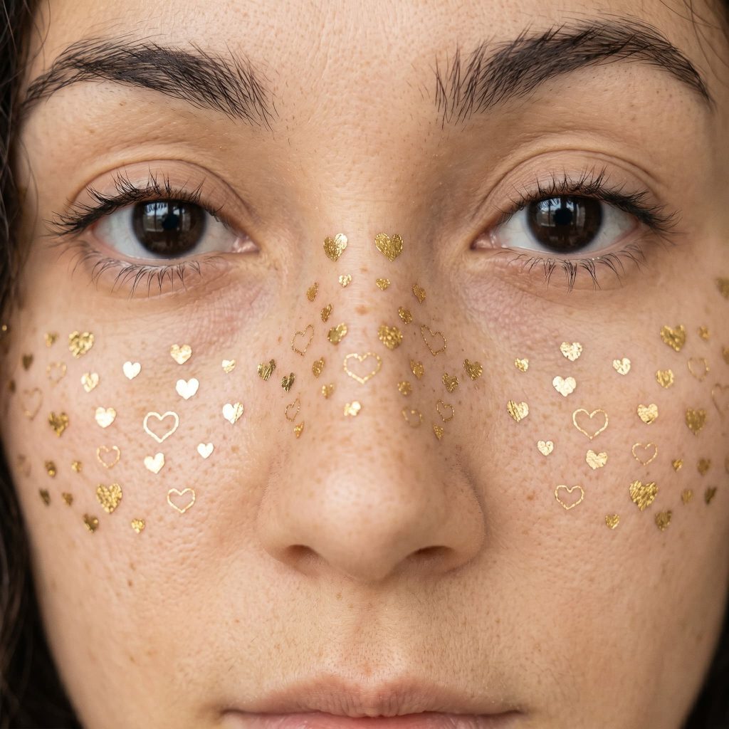 Tiny heart and star temporary tattoos worn across the cheeks
