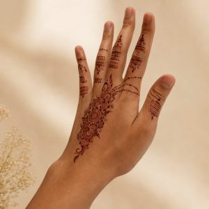 Brown mehndi floral temporary tattoo shown on the hand from an angled view