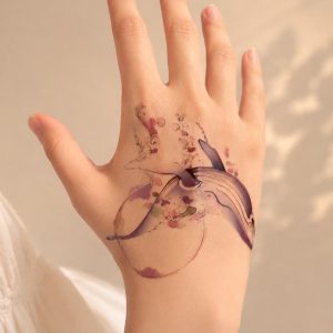 Watercolor whale temporary tattoo worn on the forearm