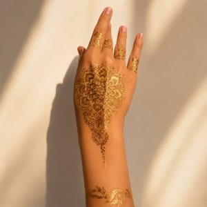 Gold mehndi floral temporary tattoo shown across the hand and wrist