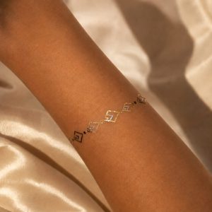 Metallic charm band temporary tattoo worn around the wrist