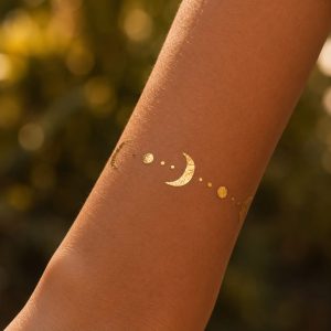 Gold moon and star temporary tattoo worn on the forearm
