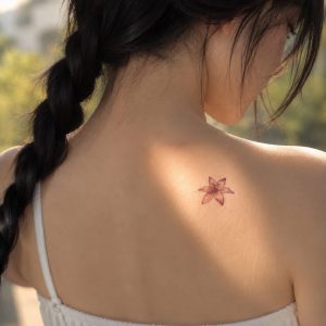 Pink lily temporary tattoo worn near the shoulder