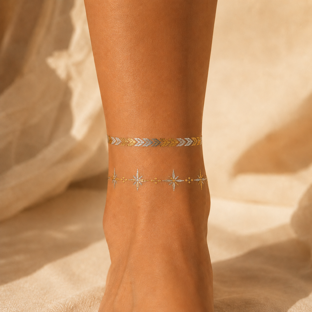  metallic gold and silver temporary tattoo bands worn on an adult ankle against champagne satin